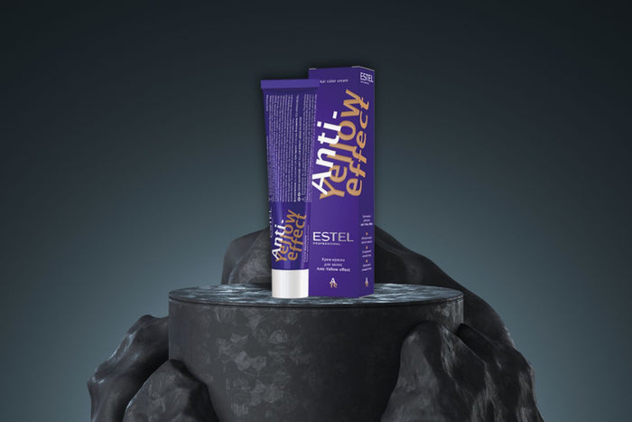 Tube und Verpackung der Estel Anti-Yellow Effect Haarfarbe in Violett auf dunklem Steinpodest.