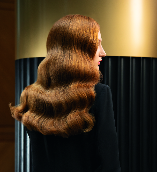 Lange kupferrote Haare in großen Wellen, Rückenansicht.