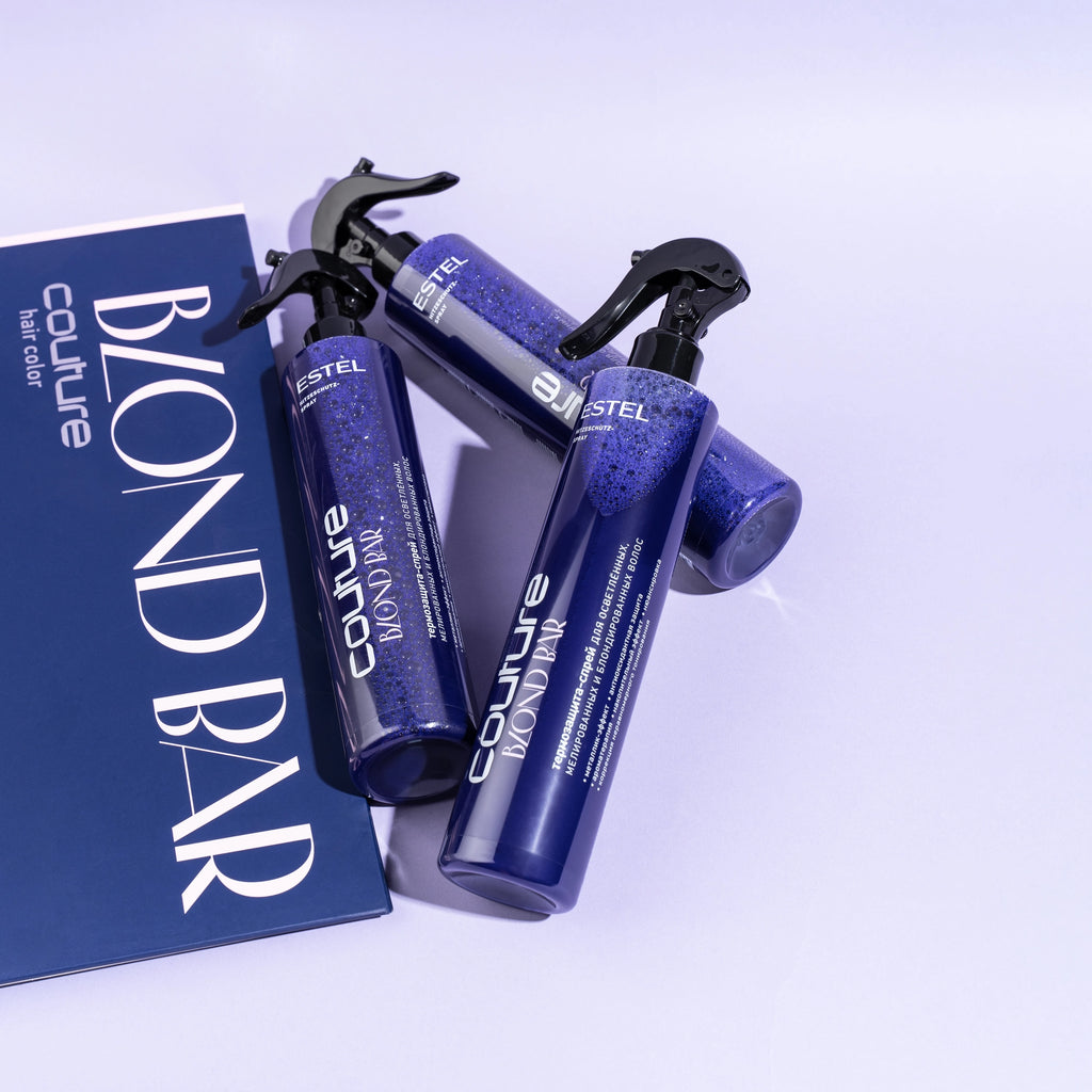 Drei dunkelblaue Sprayflaschen ESTEL Couture Blond Bar mit schwarzem Sprühkopf, daneben eine dunkelblaue Produktmappe.