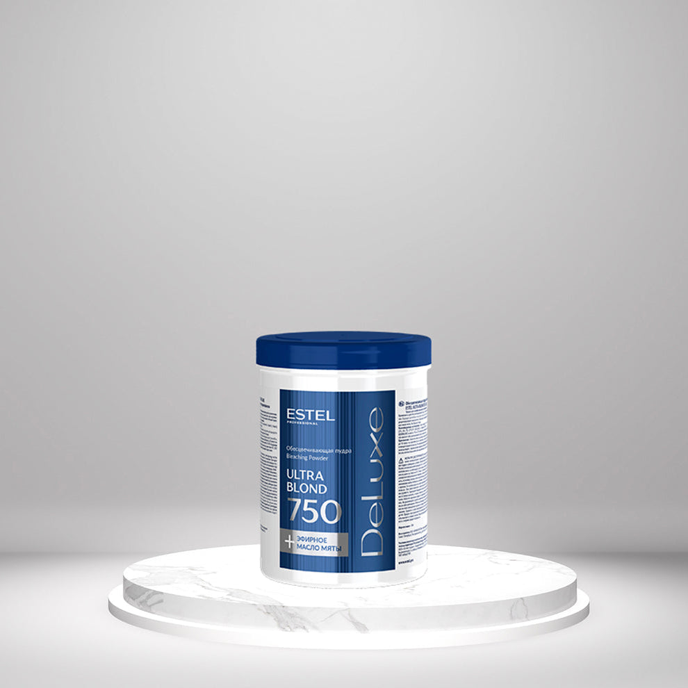 Weiße Dose ESTEL DeLuxe Ultra Blond 750 g Blondierpulver mit blauem Deckel, auf rundem Podest vor grauem Hintergrund.