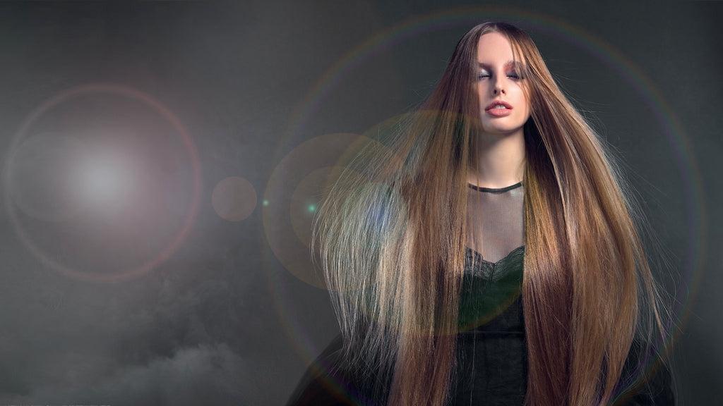 Frau mit langem, glattem, glänzendem Haar vor dunklem Hintergrund mit Lichtreflexen